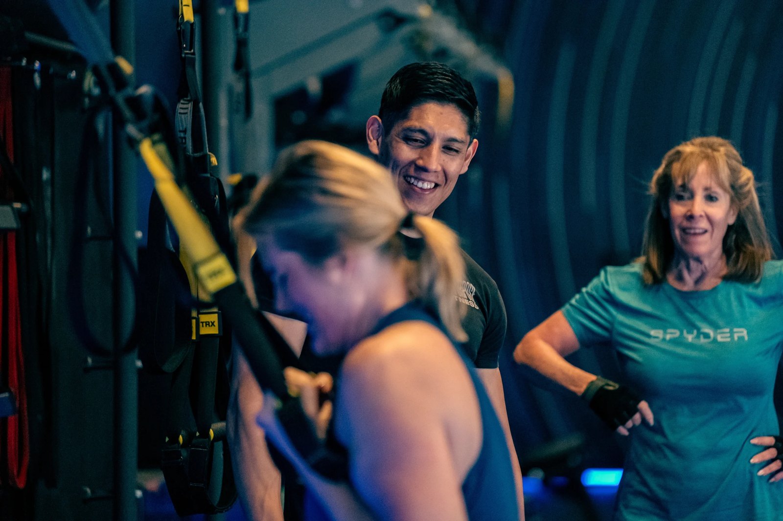 Coach guiding a member through seated resistance band rows